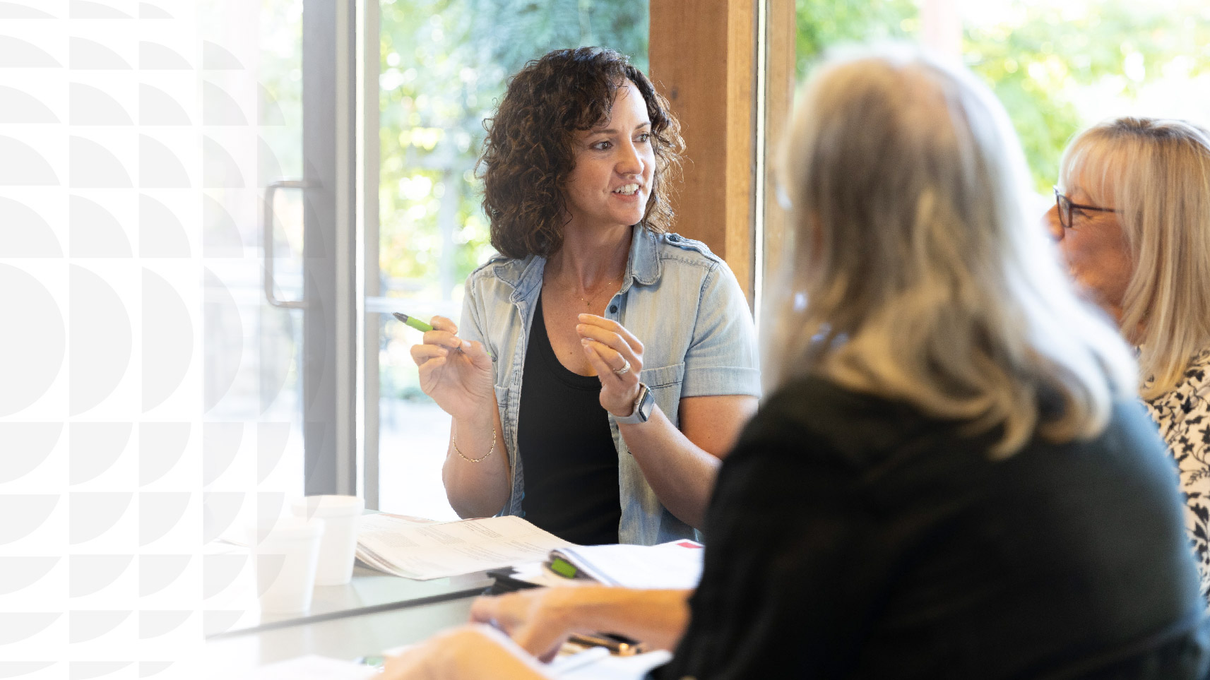 Three woman sitting at a table engaging in a conversation